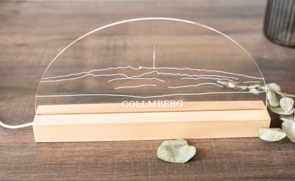 Moderner LED-Schwibbogen mit Collmberg-Silhouette auf Acryl und Holzsockel. Warmweißes Licht, 30 cm breit. Perfekt als regionale Deko oder Geschenk.